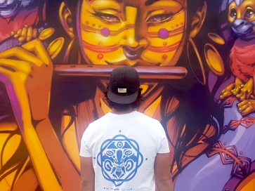 Nasca Uno in front of his mural at Lollapalooza Berlin , with his artist logo visible (photo by Anita Malhotra, Sept. 7, 2019)